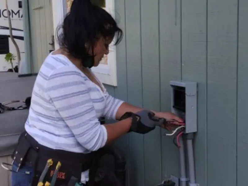 Licensed electrician wiring an exterior subpanel in Le Ray