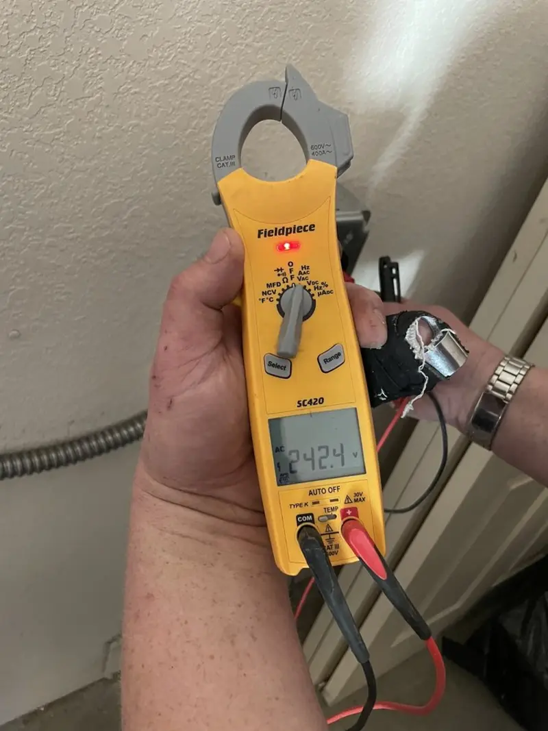 Voltage testing with clamp meter during Ceiling Fan Installation in Le Ray
